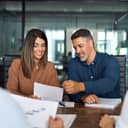 smiling business executives reviewing documents and discussing company strategy during a meeting