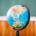 world globe positioned in a classroom with a blurred background