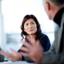 Two professionals, male and female, engaged in discussion during a business meeting.