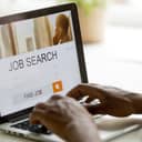 African man browsing work opportunities online using job search computer app, black jobless seeker looking for new vacancies on website page at laptop screen, recruitment concept, rear close up view