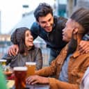 Multi ethnic group of students chatting around a table in a brewery.