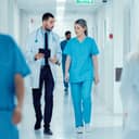 male surgeon and female doctor walking through hospital hallway