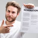 A man pointing at a resignation letter he is holding
