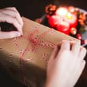 A person tying a knot on a Christmas gift