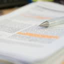 A pencil rests atop a reviewed scientific journal article.