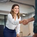 happy middle-aged businesswoman shaking hands with a client in the office