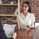 Woman being interviewed by a person holding her resume