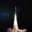 Space modern technology rocket with smoke and blast takes off to the night starry sky. Travel and space exploration, creative idea. Free space for text and design. Spaceship successful launch