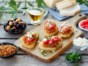 Bruschetta with olive tapenade and fresh tomatoes on a cutting board