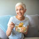 An older woman eating a salad
