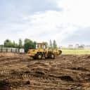 large yellow wheel loader leveling land for a new construction project on a building site