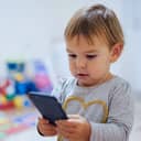 A baby using a phone, playing game or watching cartoons at home