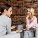 A concerned young woman discussing her mental health issues during a session with an attentive female psychologist.