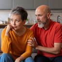 senior man apologizing to his distressed wife after a disagreement at home