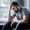 A depressed man sitting at his house