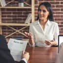 Woman being interviewed as interviewer reads her resume