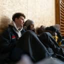 two young Ukrainian war refugees sitting on the floor at a temporary shelter