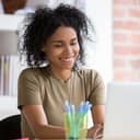 Woman smiling as she works on her laptop indoors
