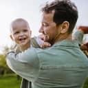 father enjoying time with his baby, playing and having fun outdoors on a warm spring day