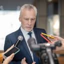Serious man. Grey-haired bearded man looking concentrated at the press conference