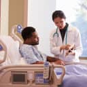 Doctor providing an explanation on tablet to a patient in bed