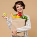 Smiling woman holding a bag of fruit and vegetables