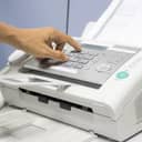 Person pressing buttons on a fax machine