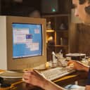 male college student surfing the internet on an old desktop computer from 1990s