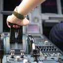 Close-up view of a captain's hands in a commercial airplane cockpit as they adjust the throttle.