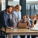team of four people engaged in a meeting in the office of a digital marketing agency