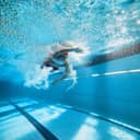 young male swimmer swimming the freestyle stroke in a pool
