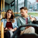 A young couple engaged in a tense conversation while riding on public transportation.