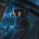 young man sleeping soundly in bed at night