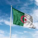 The national flag of the People's Democratic Republic of Algeria against blue skies.