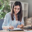 A happy woman writing in her notebook