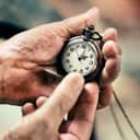Close-up of elderly hands clutching a vintage pocket watch