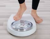 Person about to step onto a scale to weigh themselves
