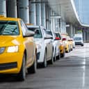 A row of taxis in front of an airport entrance