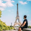 picture of a man during his summer vacation in Paris, with the Eiffel Tower in the background