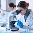 Young female scientist in a laboratory looking through a microscope