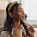 young woman sitting on a sofa at home, enjoying ice cream and relaxing