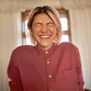 A young woman with a piercing on her nose giggling with her eyes closed