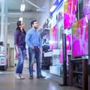 Couple browsing for big screen TVs at a shop