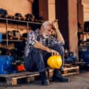 An overworked middle aged man sitting on a wooden pallet
