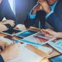 business people in a meeting discussing a downturn in market performance and analyzing results