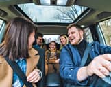 Five people inside a car sharing a laugh