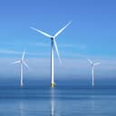 three windmills in a wind farm against a backdrop of clouds and blue sky in the Netherlands