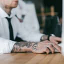 Tattooed man in formal attire working in an office