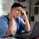 Young Asian businessman looking serious and stressed while using laptop to work from home