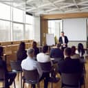 young man delivering a presentation or report to colleagues in a business room